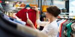 A woman looking at the price tag of an item of clothing in a store