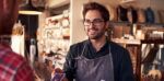 shop worker smiles as a shopper makes a purchase with a credit card