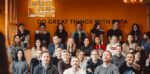 group of colleagues sat on bleacher setting in an office