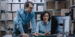 two people looking at a laptop in a stock room