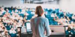 Woman delivering a presentation to an auditorium of people